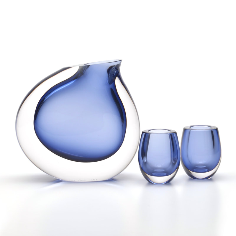 a blue modernist glass pitcher set sculpture with a white background